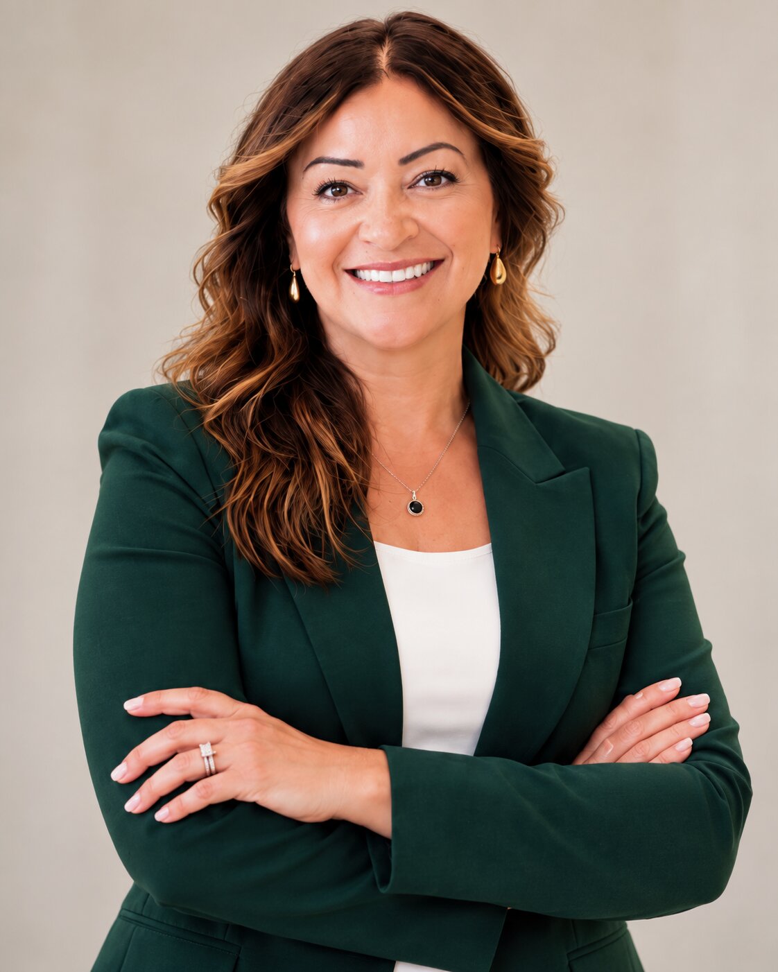 Janel Rose, REALTOR®, smiling with arms crossed in a hunter green blazer